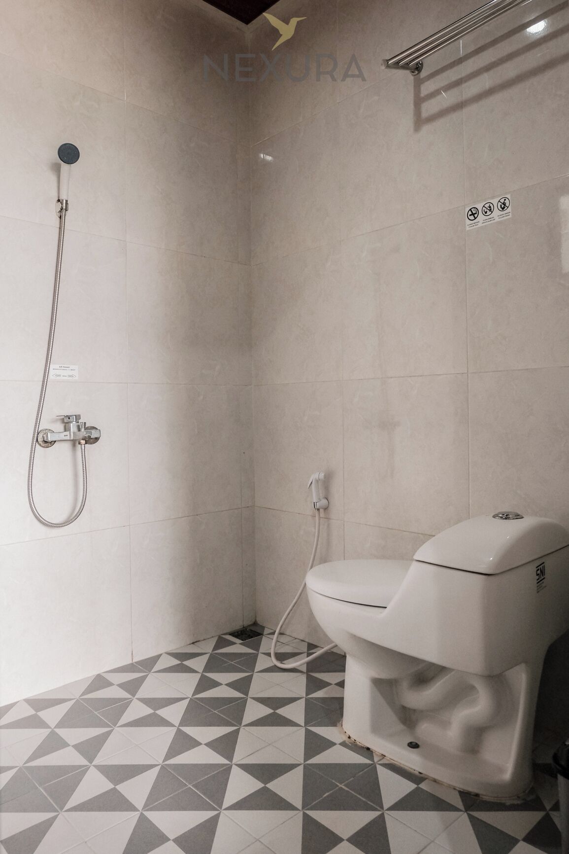 Un baño con ducha, inodoro y suelo de baldosas.
