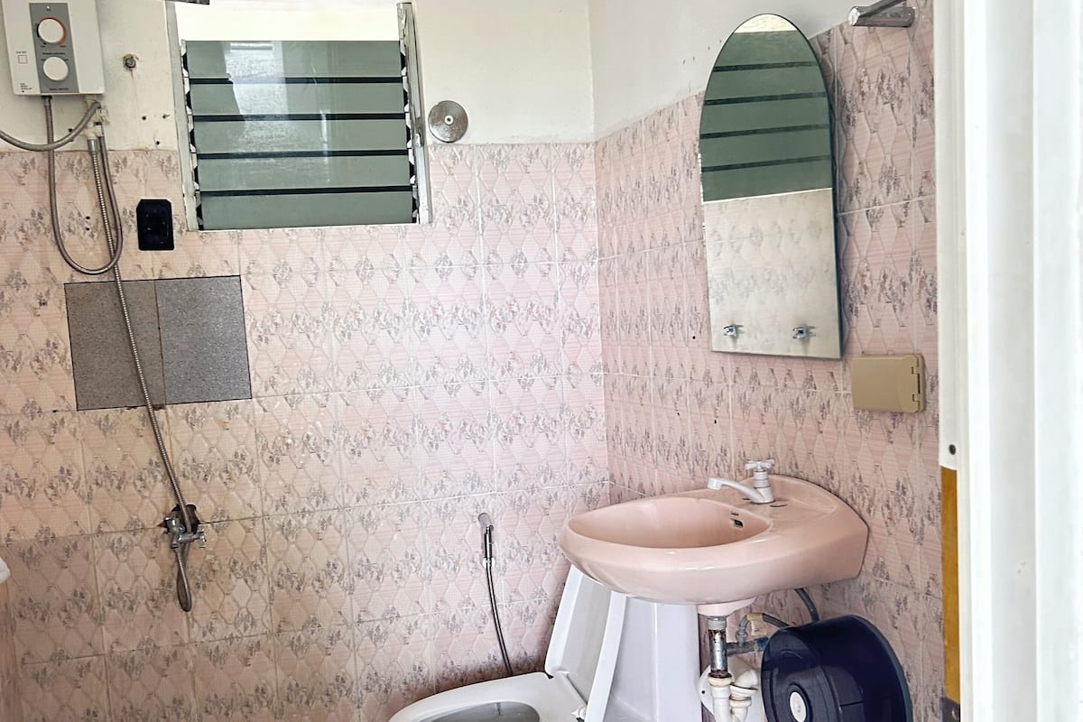A bathroom with a toilet, sink, and shower.