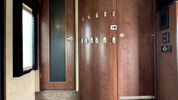 A set of wooden steps leading to a door with multiple locks and a keyhole.