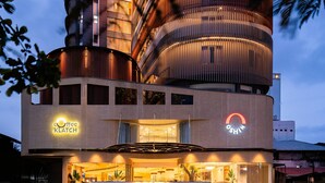 A modern building with a cylindrical design, featuring a coffee shop named 'Coffee Klatch' and a sign for 'OSHIN'. - Oshin Calicut (Kozhikode)