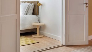 A bedroom with a bed, a bedside table, and a door leading to another room. - Former Dukes Residence - 4 bedrooms - 2 bathroms (København)