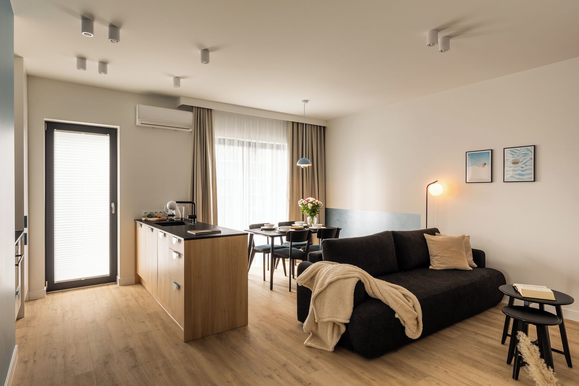 A modern apartment with a kitchenette, a dining area, and a living room.