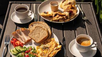 A table set with breakfast including toast, eggs, vegetables, and coffee.