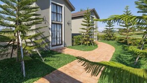 A modern house with a paved driveway and a well-maintained lawn. - Chunnchay Bed&Restaurant (Mae Wang)