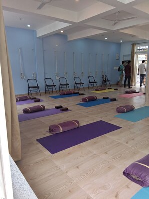 A yoga studio with mats and chairs arranged for practice. - Himalayan Wellness Retreats (Rishikesh)