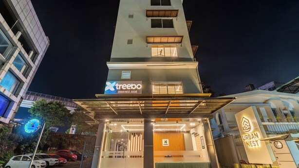 Egy modern épület, amelyen a „Treebo Urban Nest” feliratú tábla látható, és jól felismerhető a bejárata.