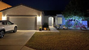 A residential house with a garage, driveway, and well-lit exterior. - 4-bedroom house in an amazing neighborhood with AC, WiFi. Relax and unwind. (Imperial)