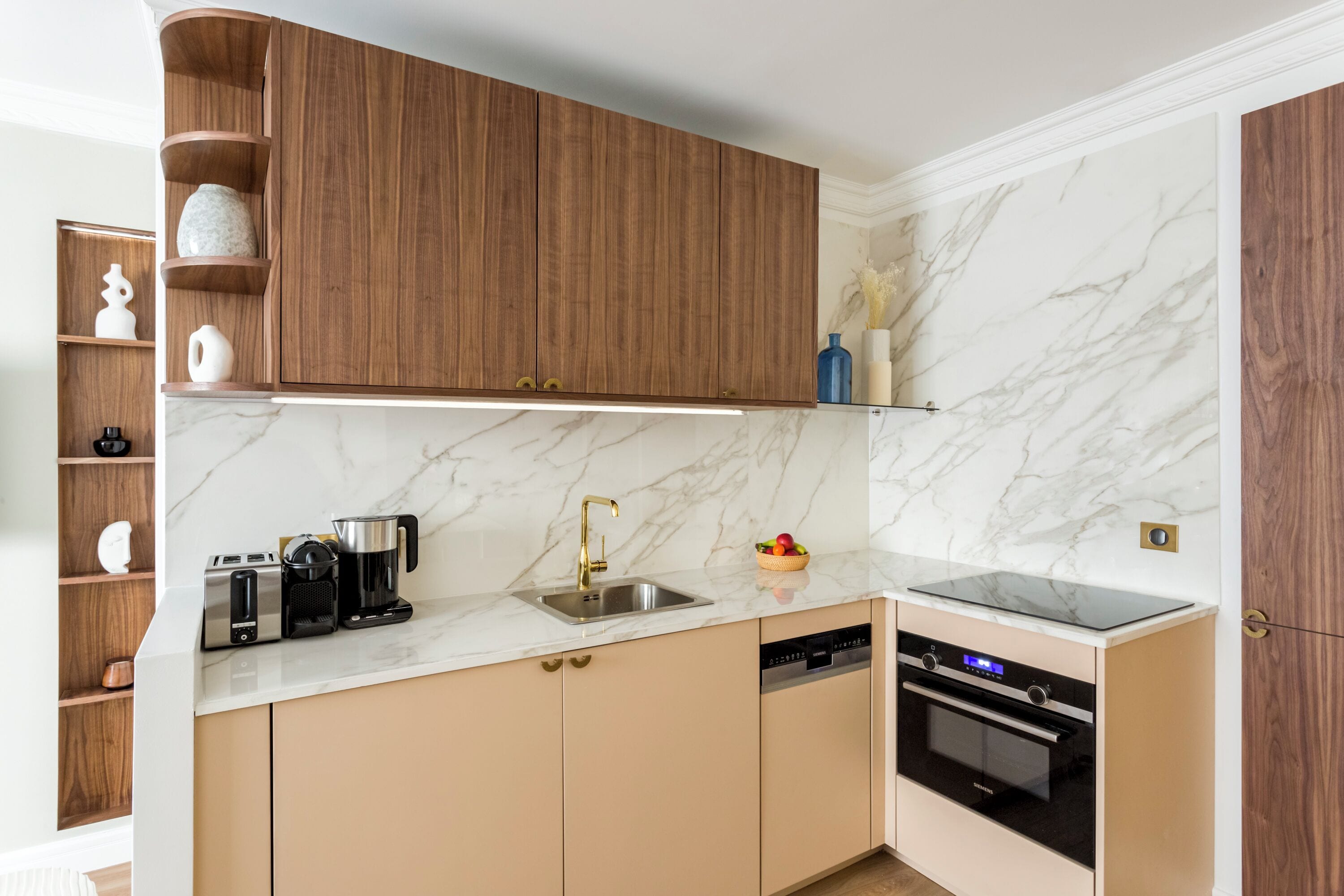 A modern kitchen with wooden cabinets, a marble backsplash, and built-in appliances including a dishwasher and oven.