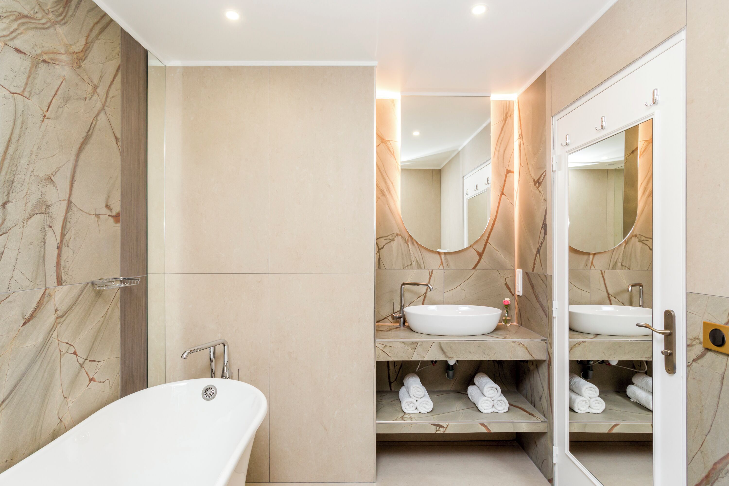 Un bagno moderno con una vasca freestanding, un mobile lavabo e uno specchio.