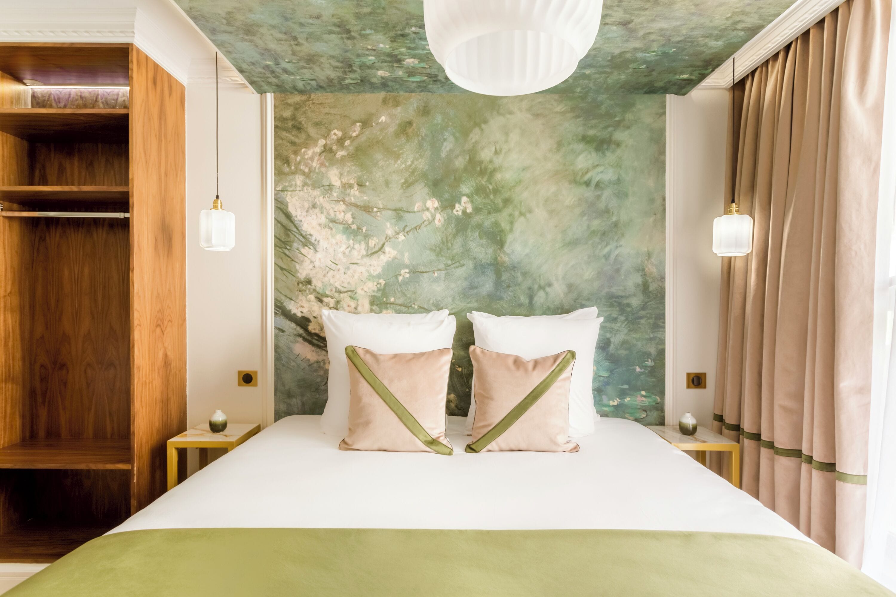 Ein ordentlich eingerichtetes Schlafzimmer mit einem großen Bett, zwei Nachttischen, einem Kleiderschrank und einer Wand mit Grüner Struktur.