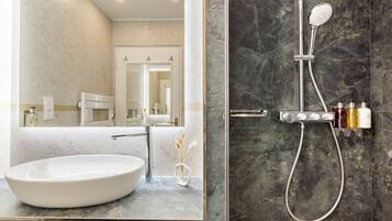 A modern bathroom with a large oval sink, a handheld showerhead, and a marble-tiled shower enclosure.