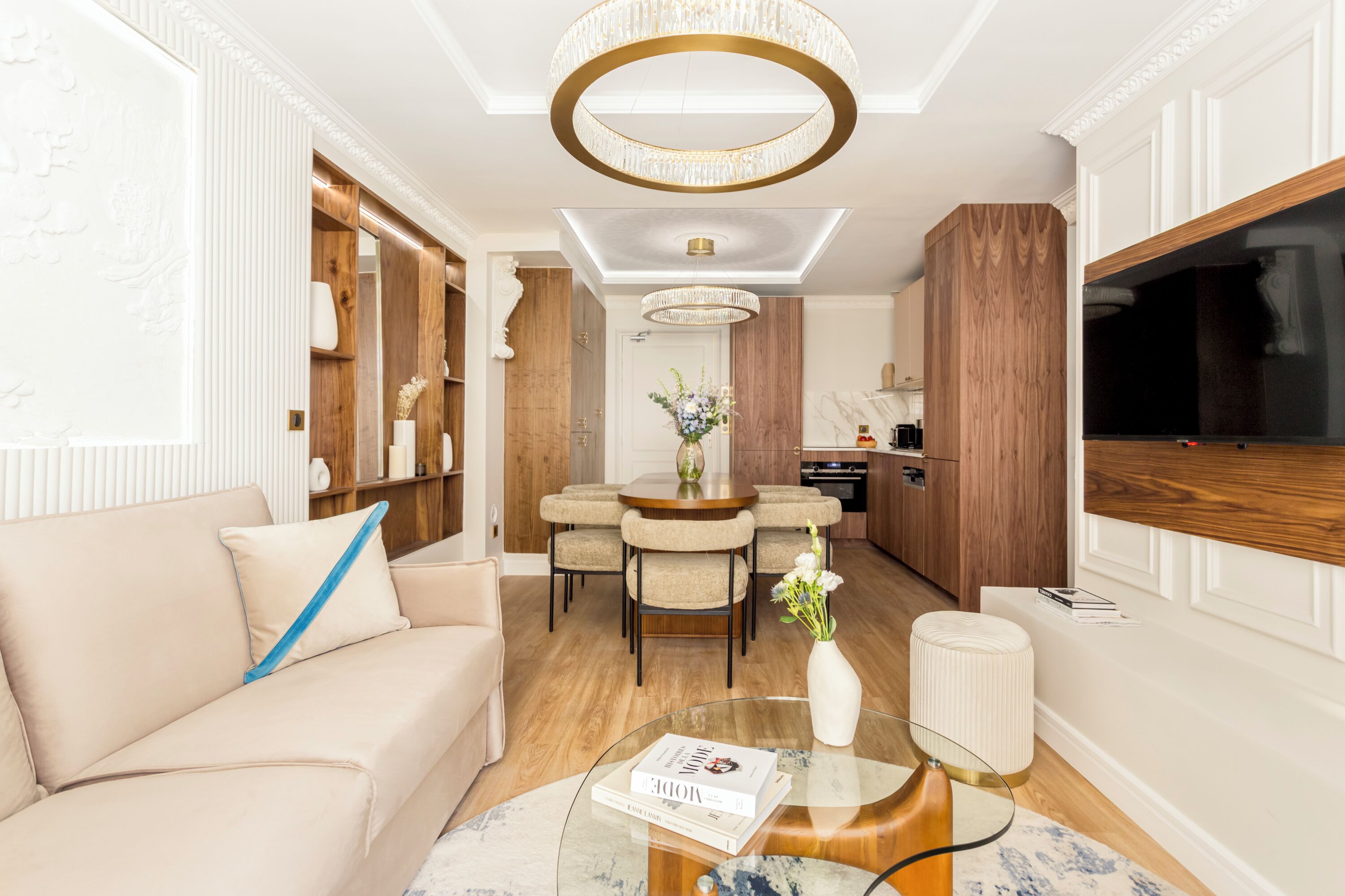 Een moderne woonkamer met een bank, een salontafel en een eethoek met stoelen.