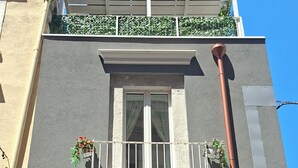 Un edificio con un balcón, una ventana y una puerta.