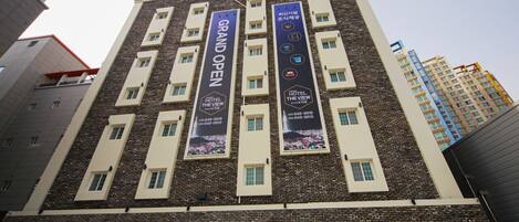 Un hotel de varios pisos con pancartas anunciando Gran Inauguración y Hotel The View.