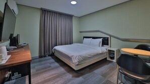 A hotel room with a bed, desk, chair, and a small table. - Unique Hotel The View (Tongyeong)