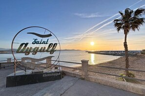 Une vue sur la plage avec un panneau indiquant « Saint-Agulf » et un hashtag « #SaintAgulf ».