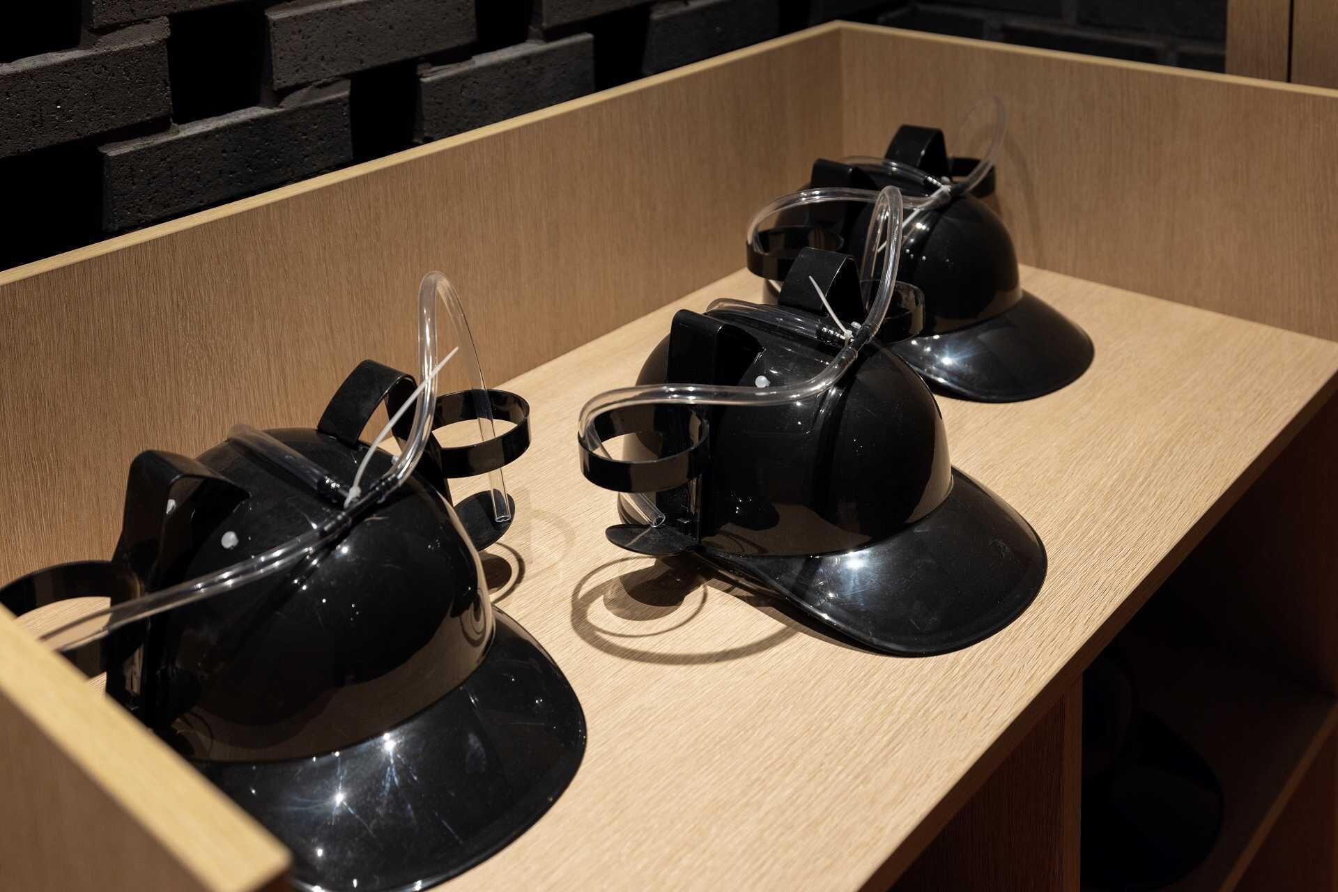 A wooden display case containing two black, spherical objects with transparent components.