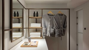 A modern bathroom with a mirror, shelves with toiletries, a towel rack, and a tray with a cup and book. - Ondo Hotel and Spa Seoul Jongro (Seoul)