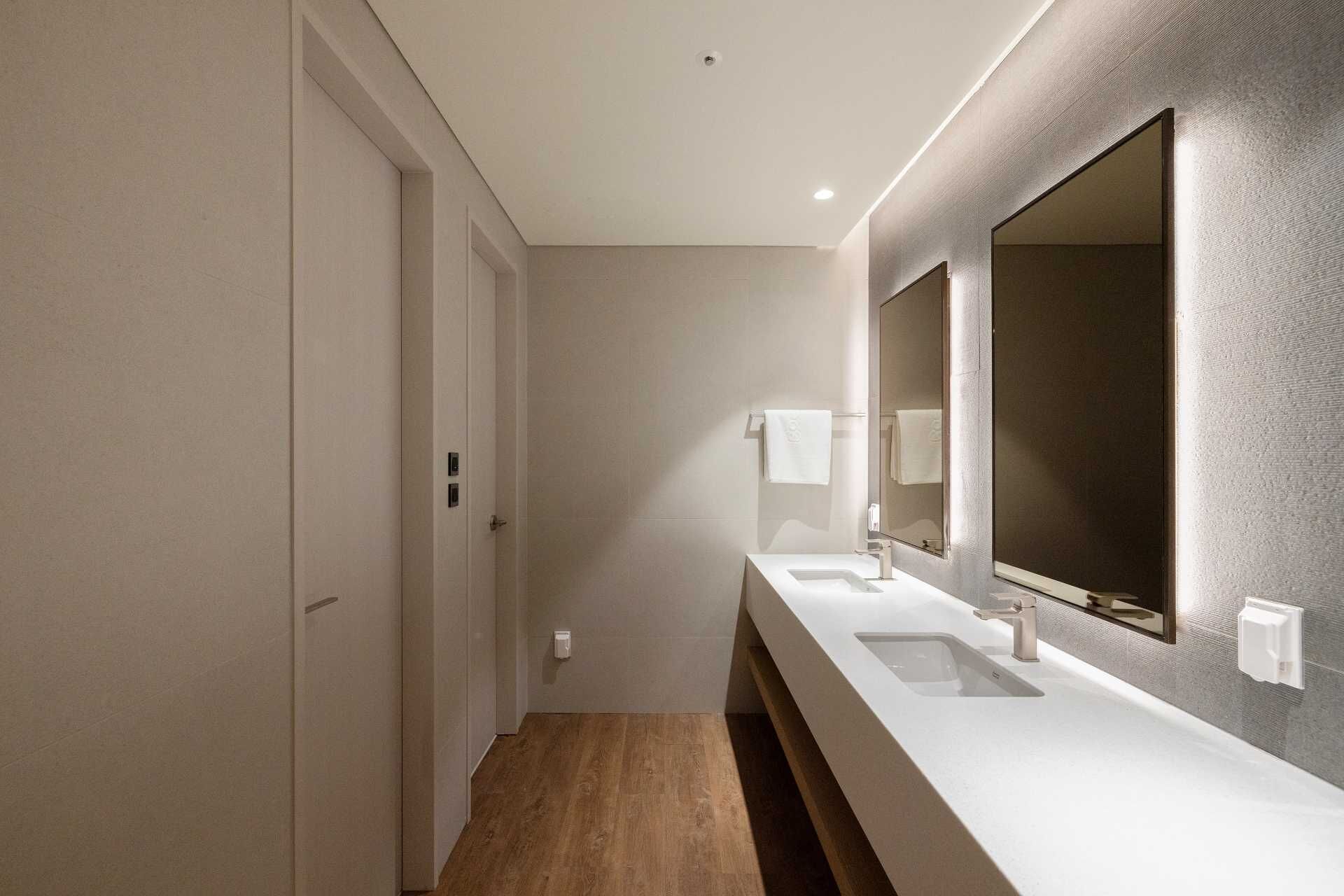 A modern bathroom with a long vanity, two sinks, and a large mirror.