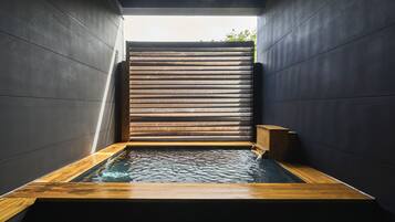 Een aparte badkuip en douche, een haardroger, handdoeken, zeep