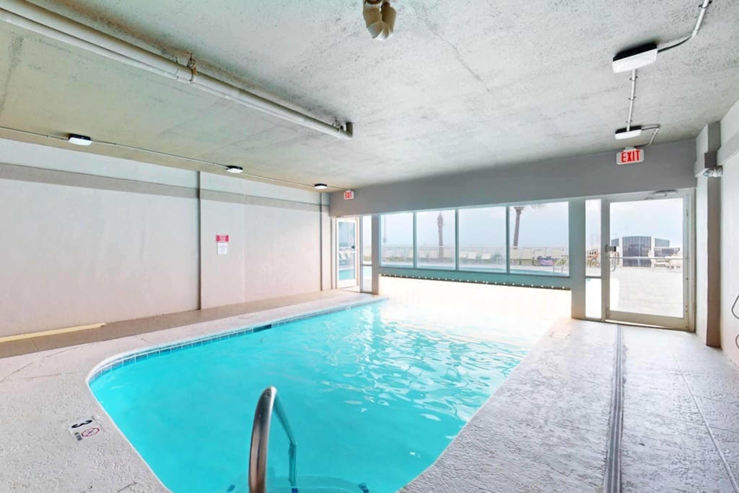 Piscina com vista ampla para o exterior através de grandes janelas.