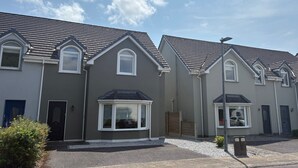 Une rangée de maisons modernes aux façades grises et aux toits à deux versants.