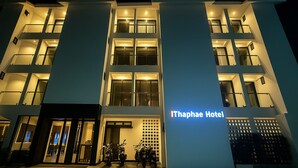 Un hotel moderno con una entrada destacada, varios balcones y un letrero que dice "Ithaphae Hotel".