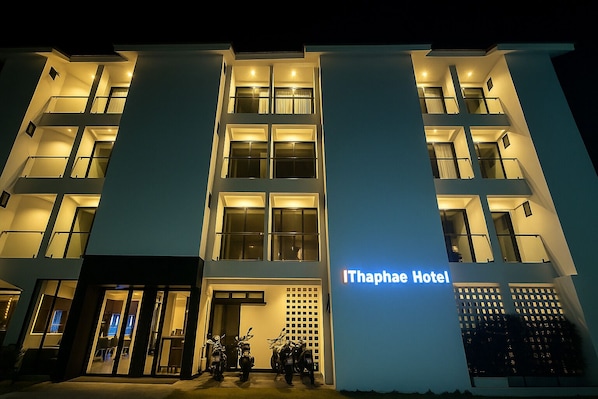 A modern hotel with a prominent entrance, multiple balconies, and a sign reading "Ithaphae Hotel". - iThaphae Hotel (Chiang Mai)