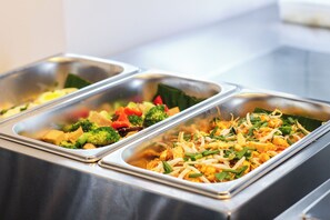 A buffet with various dishes including vegetables and stir-fried items. - iThaphae Hotel (Chiang Mai)