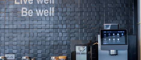 Une cuisine moderne avec un dosseret de carreaux noirs et une machine à café.