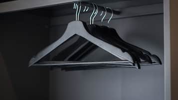 A closet with a metal hanger rack holding several black hangers.