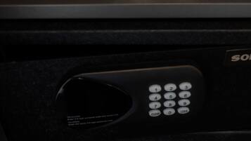 A black suitcase with a remote control and a pair of slippers inside.