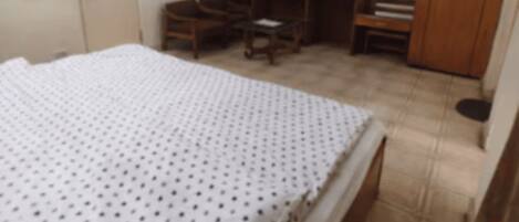 Un dormitorio con cama, televisión, armario y escritorio.