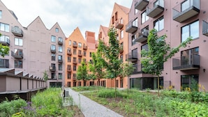 A modern apartment complex with multiple buildings, balconies, and a garden area with pathways. - Apartamenty Sun & Snow Granaria (Gdansk)