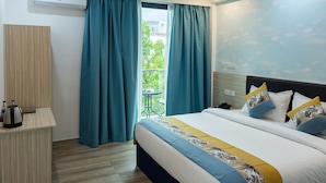 Une chambre d’hôtel équipée d’un lit, d’un bureau, d’une machine à café et offrant une vue sur l’extérieur.