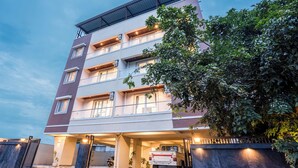 Un hotel a più piani con parcheggio coperto, pavimento a scacchi e un veicolo parcheggiato.