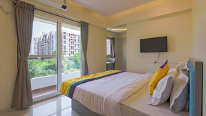 Una camera da letto con un letto, una TV, una finestra e un condizionatore.