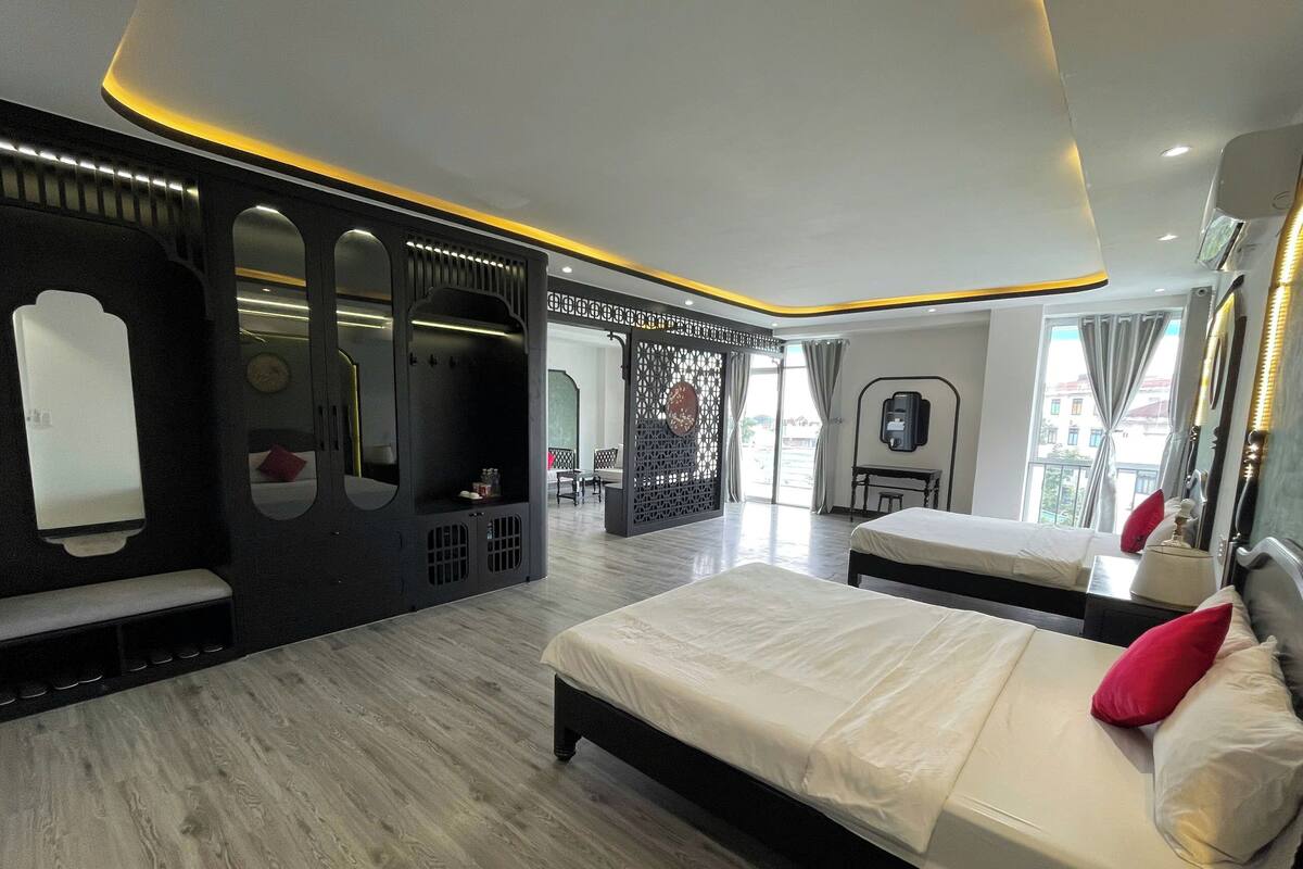 Una habitación de hotel moderna con una cama grande, un escritorio y una zona de estar.