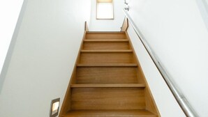 A wooden staircase with a metal handrail and a small window at the top. - Lake Toya and Nakajima (Toyako)