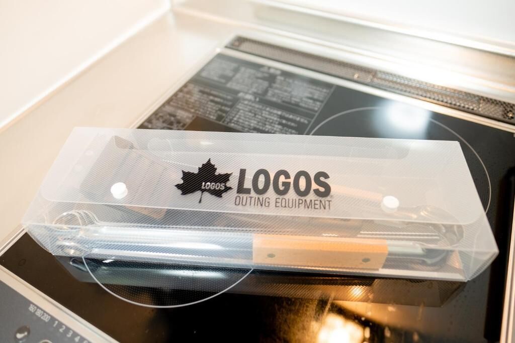 Un sac en plastique transparent avec le texte « LOGOS OUTING EQUIPMENT » imprimé sur un fond noir.