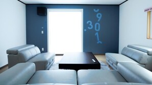 A modern living room with a sectional sofa, a coffee table, and a large window. - Lake Toya and Nakajima (Toyako)