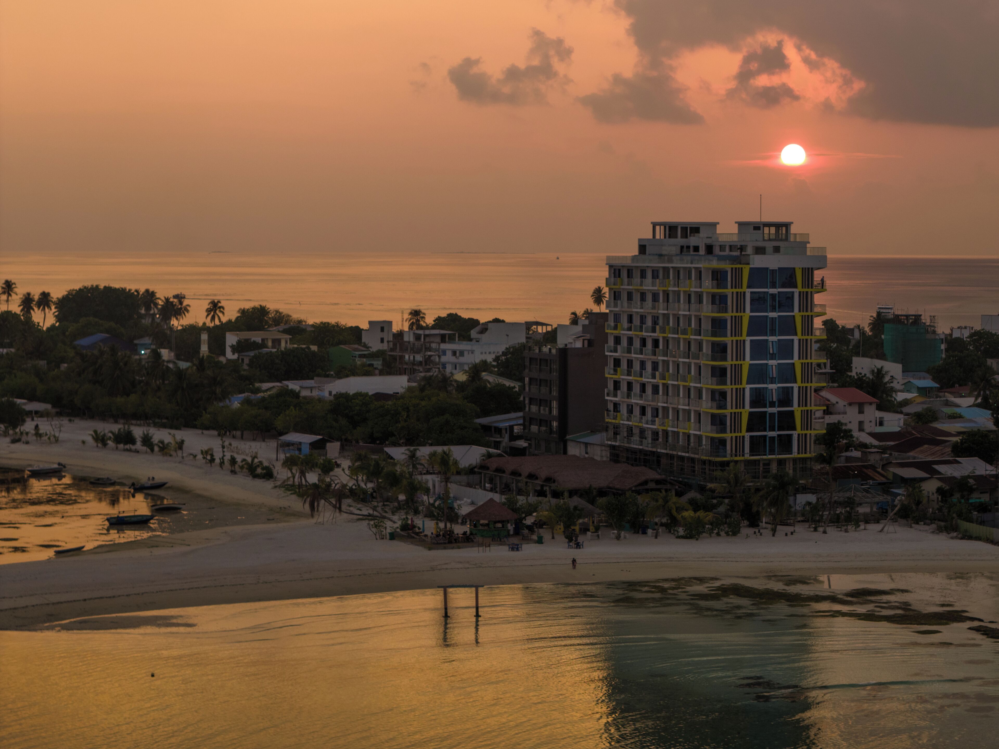 A coastal hotel with a view of the ocean and a beach.