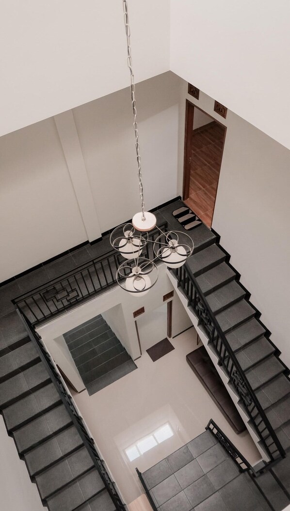Un intérieur moderne avec un escalier, un coin repas et un téléviseur fixé au mur.