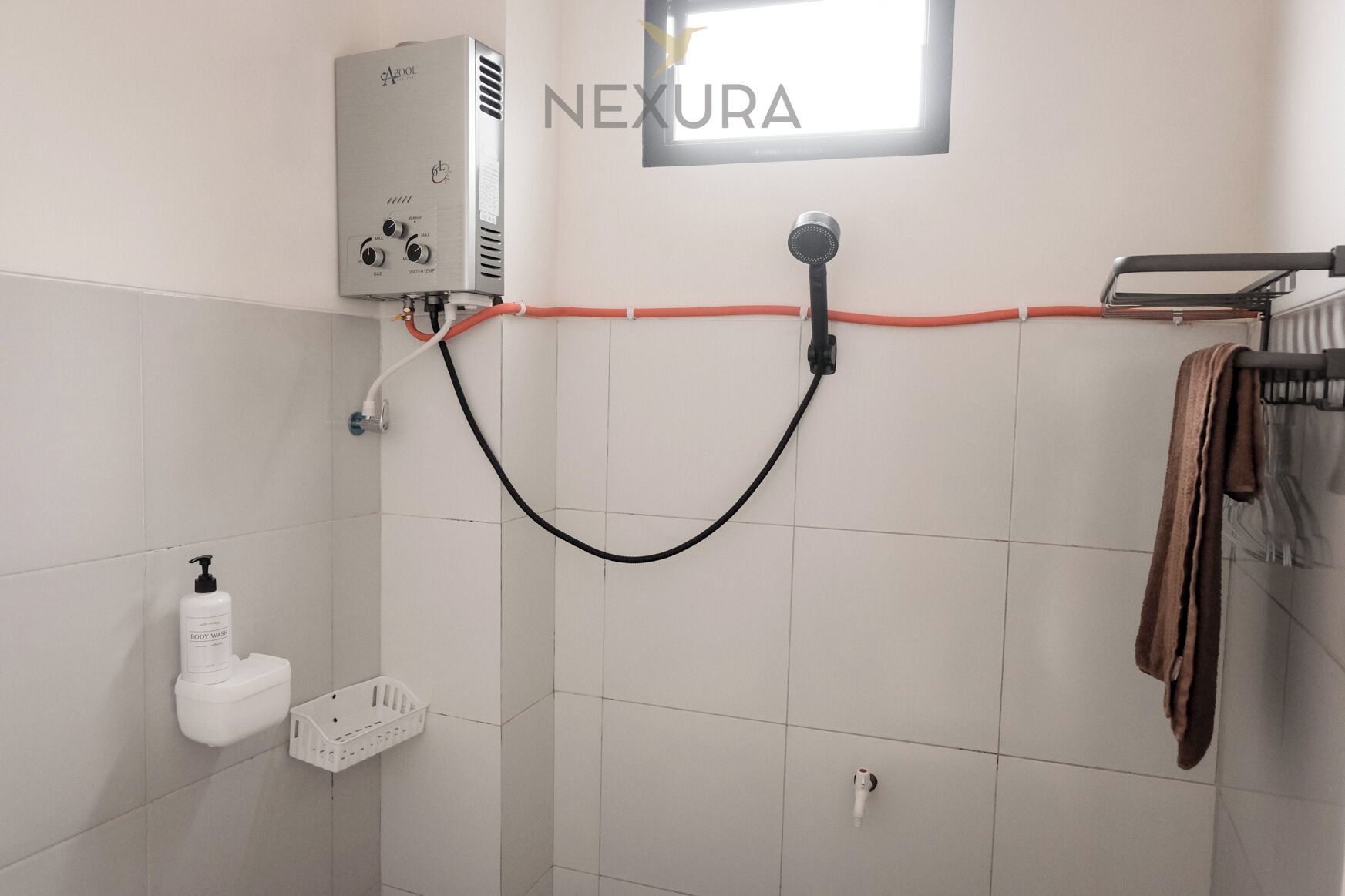 Un bagno con uno scaldabagno, un portasciuga e un soffione doccia.