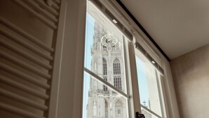 A window with a view of a historic building. - A Place - Oude Koornmarkt 1 (Antwerp)