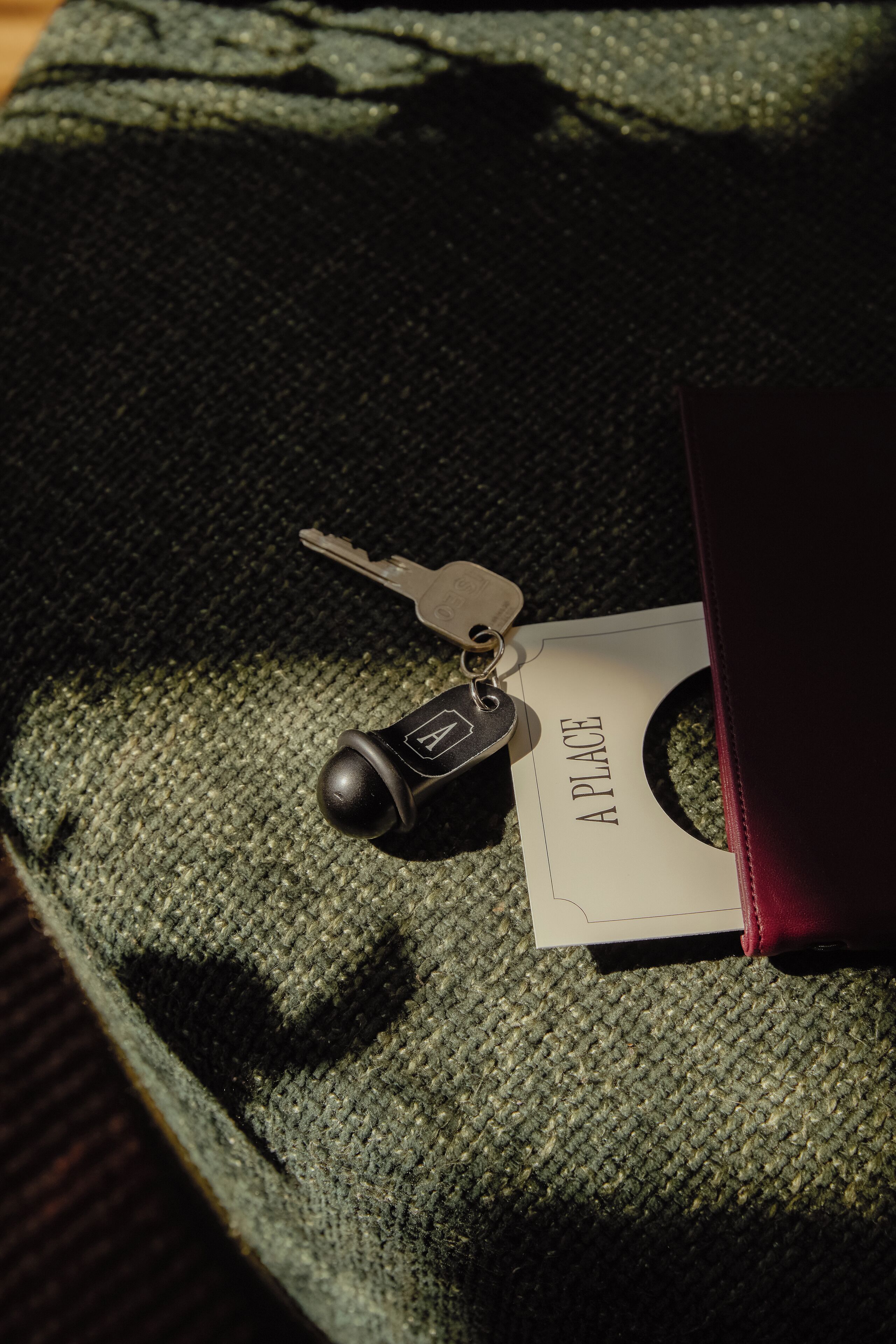 Un porte-clés avec une clé et une étiquette fixés sur une surface en tissu texturé.