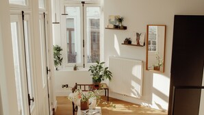 A staircase leading to a room with a wooden floor, a chair, a table with plants, and a mirror on the wall. - A Place - Oude Koornmarkt 1 (Antwerp)