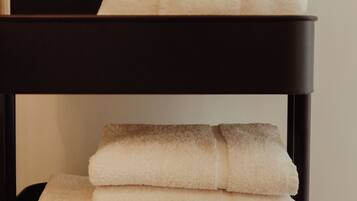 A black shelf with folded towels.