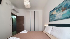 A hotel room with a bed, a painting, and a door. - MareLuce by Interhome (Balestrate)