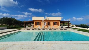 A modern house with a pool, outdoor seating, and a clear blue sky. - MareLuce by Interhome (Balestrate)
